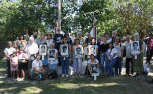 Group photo of participants holding photos of slain sisters.